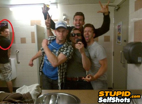 Guy group's self shot photobombed in the bathroom